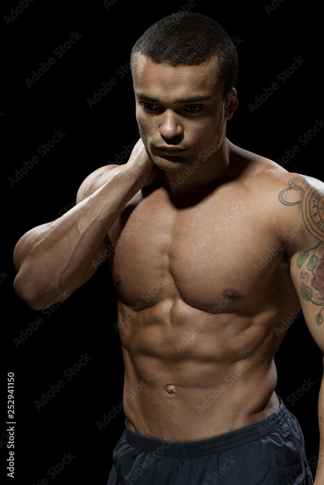 Fototapeta premium Hard work pays off. Handsome young bodybuilder showing off his hot body