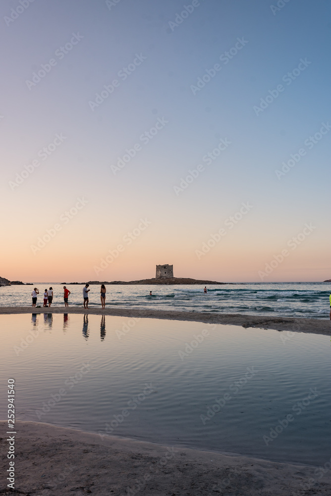 Obraz premium Ragazzi camminano sulla spiaggia al tramonto al mare.