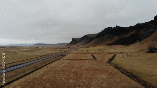 Icelandic cliffs on the southern coast with the ringroad and passing cars near foss a sidu  photo