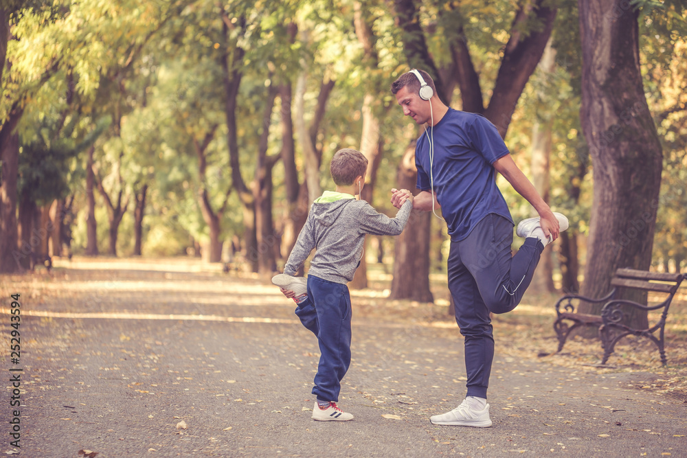 Little boy and his father exercising together outdoors