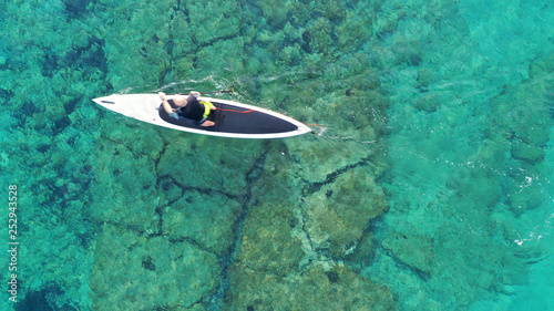 Aerial photo of man with his sup paddle board in coast of caribbean clear sandy seascape