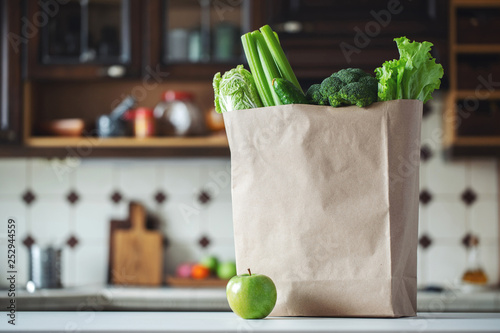 Fototapeta Naklejka Na Ścianę i Meble -  Fresh green vegetables and fruits in a paper bag.