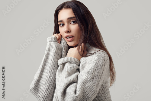 Beautiful brunette woman in sweater posing in studio © micro