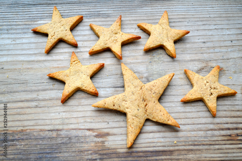 Gingerbread cookies in shapes of heart, star and man with cinnamon stick and ginger root on wooden table Gingerbread cookies in shapes of heart, star and man with cinnamon stick and ginger root on wooden table