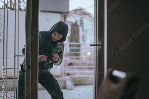 Intruder trying to open door with wrecking bar © qunica.com