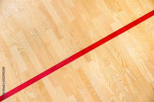 Red line on the gymnasium floor for assign sports court. Badminton, Futsal, Volleyball and Basketball court