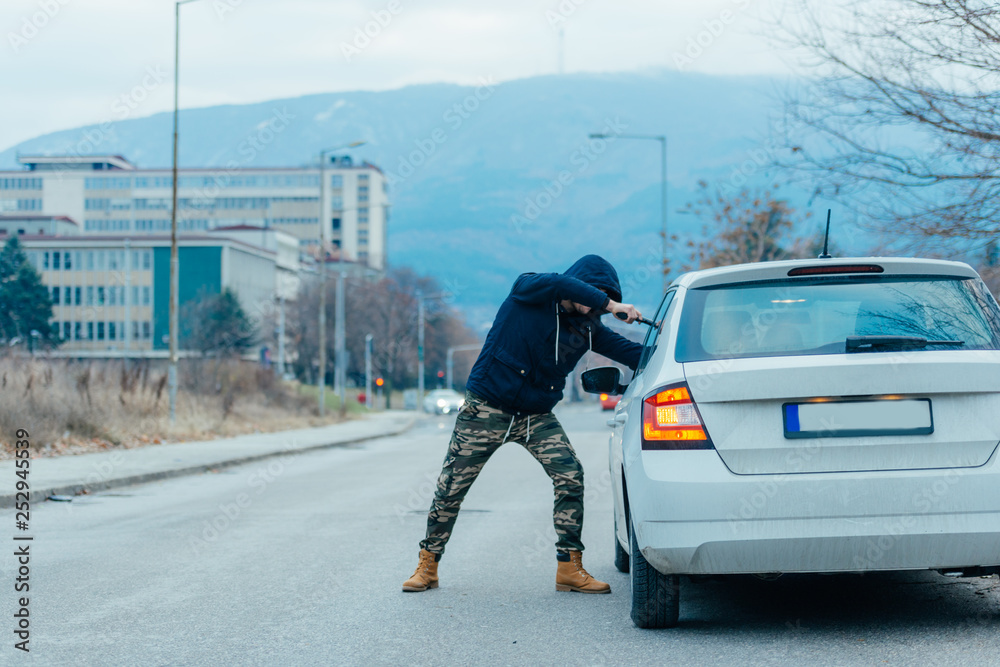 Fototapeta premium Gangster with a gun trying to rob a guy which is sitting in his car.