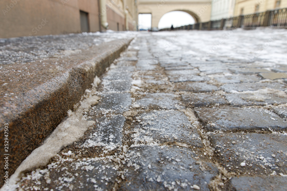 Deicing chemicals on the pavement. Pavement is sprinkled with technical salt or salt mixtures