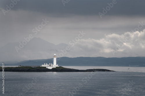 Lismore Lighthouse on Eilean Musdile Islet off Lismore Island with rain and clouds over the west coast highlands Scotland UK