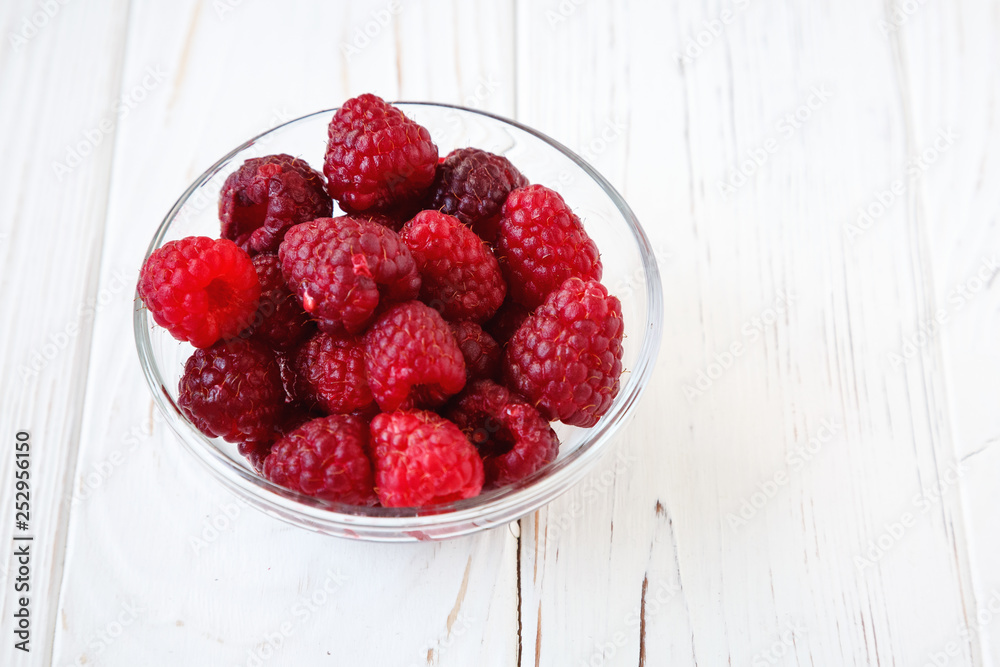 Little glass plate with raspberry on white wooden table. Healthy meal, summer fruits. Little glass plate with raspberry on white wooden table. Healthy meal, summer fruits.