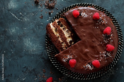 Chocolate cake with fruits on dark background. Top view with copy space.