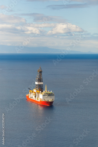 offshore oil and gas drillship, blue sea background, aerial view