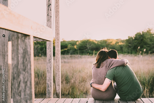 Tableau sur toile Couple in love embraced on their backs to reconcile and celebrate their love, sitting in nature