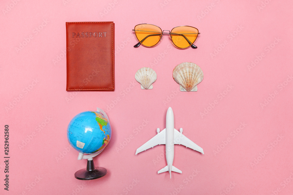 Obraz premium Vacation travel summer weekend sea adventure trip concept. Minimal simple flat lay with plane passport sunglasses globe and shell on pink pastel trendy modern background