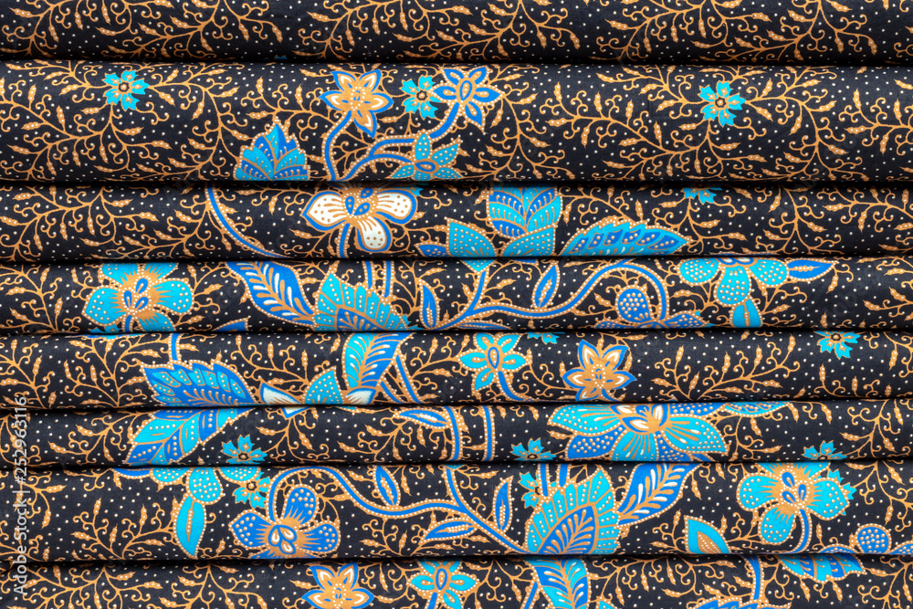 Thai flower patterned fabric folded stacked.
