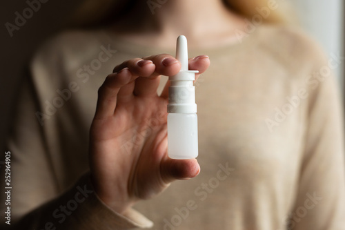 Foto The girl uses spray on a dark background. Medicine and treatment