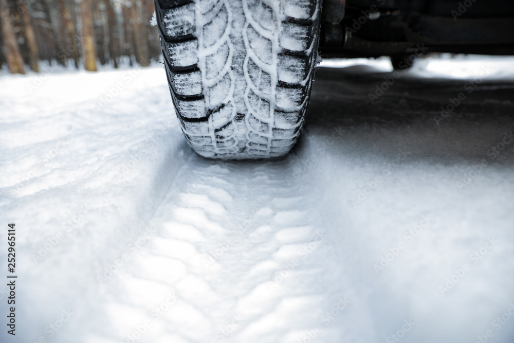 Car on snowy road, closeup. Winter season Car on snowy road, closeup. Winter season
