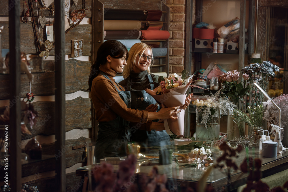 Gardener's in the flower shop make bouquet for a holiday. Family flower's business.  Lifestyle flower shop. Beautiful flower composition. Detail. Close up.