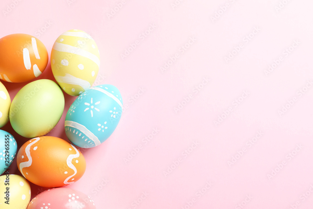Many painted Easter eggs on color background, top view. Space for text
