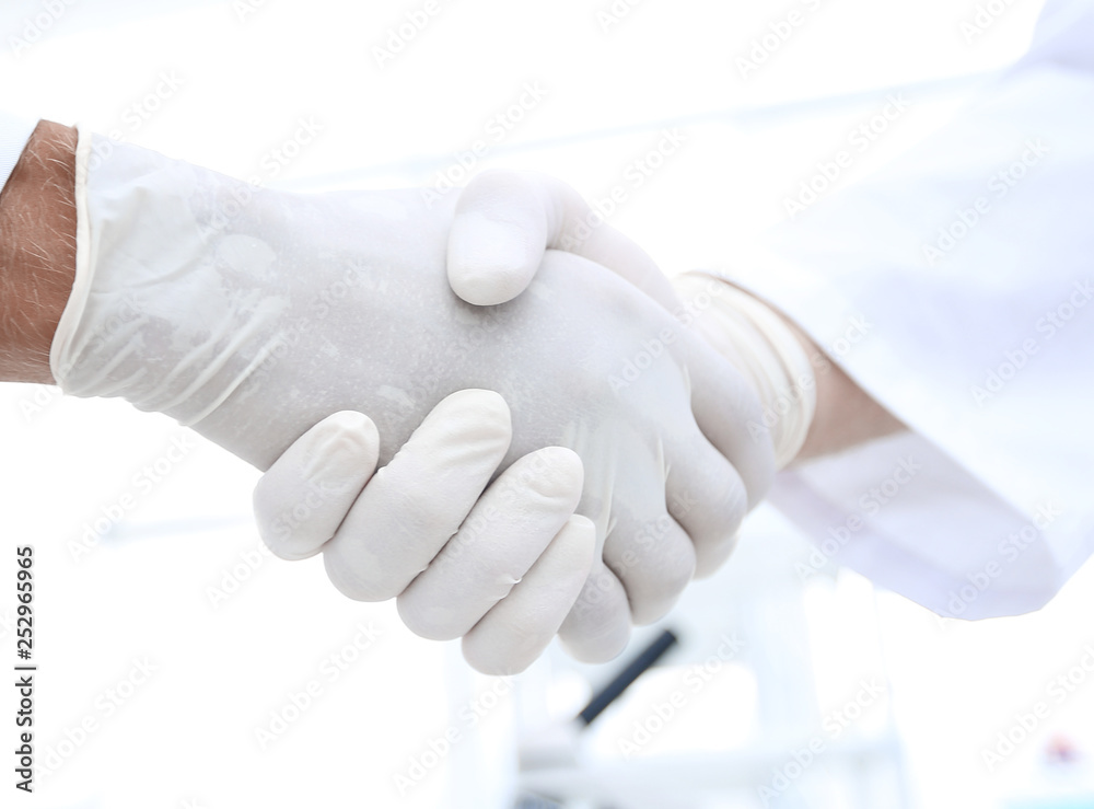 Handshake with white medical gloves Handshake with white medical gloves