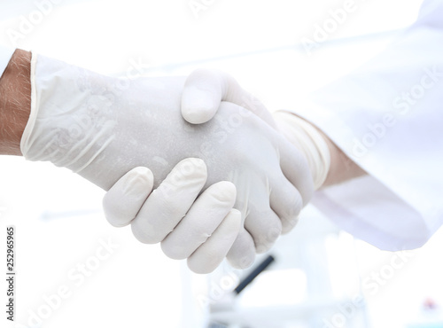 Handshake with white medical gloves