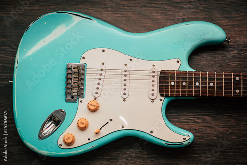 Photo Light blue electric guitar against brown wood background