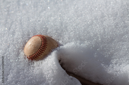 Baseball stuck in fluffy white snow during winter season