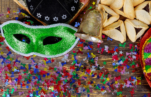 Purim jewish holiday with purim mask and purim a noisemaker on a vintage wood background with copys pace photo