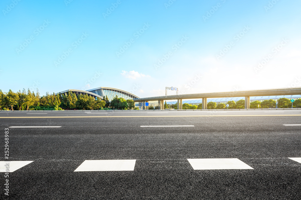 Fototapeta premium Empty asphalt road and railway station buildings in Shanghai