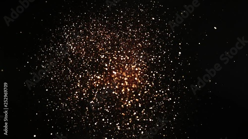 Golden glitter explosion in super slow motion on blacg background. photo