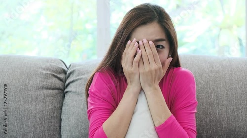 Young attractive asian woman sitting on couch at home watching a horror movie. Scarely mood. Lonely woman life style concept. photo