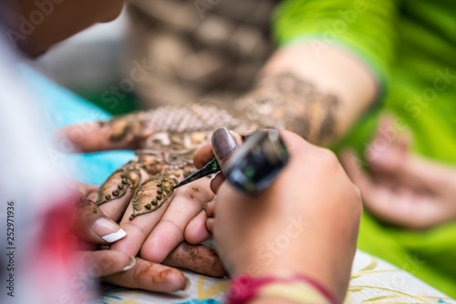 Woman gets traditional mehendi henna decoration for a Hindu wedding