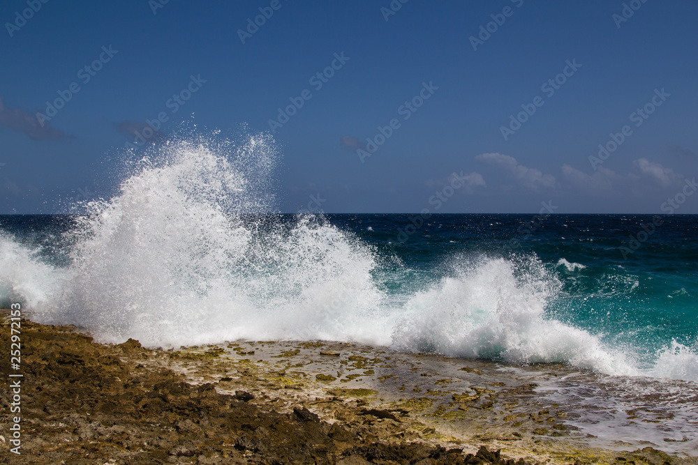 Wild and high waves breaking at the rough shoreline of the east coast of the island of Bonaire