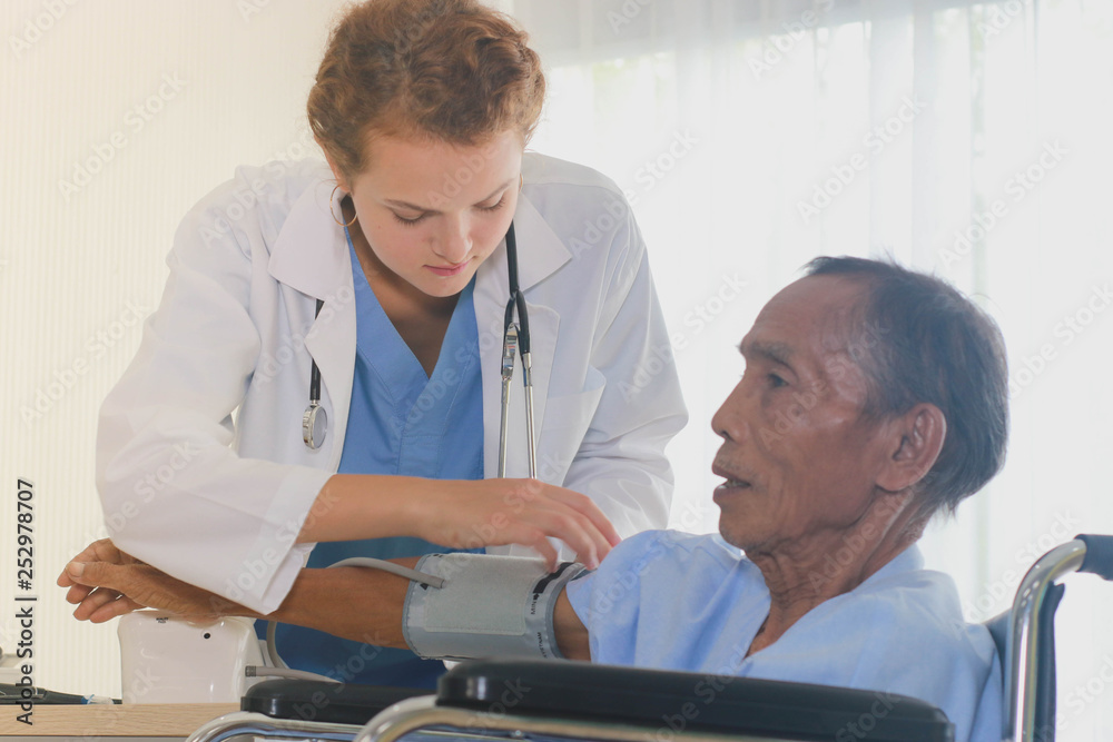 Obraz premium The doctor is checking the elderly sitting on the cart.