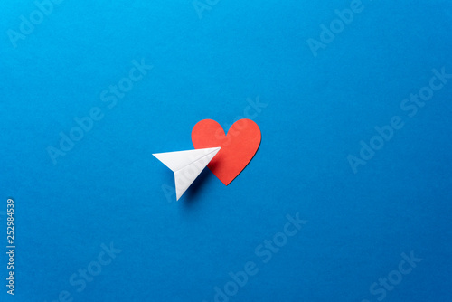 Paper plane with red heart shape on blue background. Sharing and send concept.