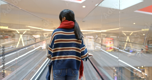 Woman take escalator in shopping center