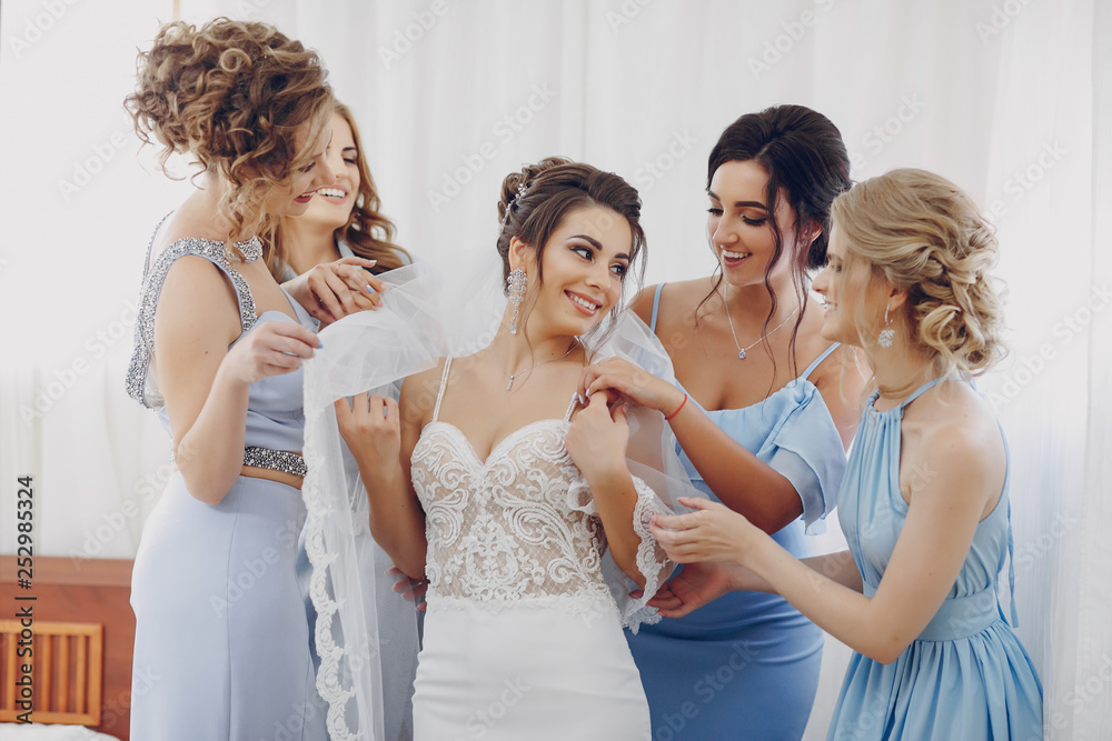 elegant and stylish bride along with her four girlfriends in blue dresses standing in a room elegant and stylish bride along with her four girlfriends in blue dresses standing in a room