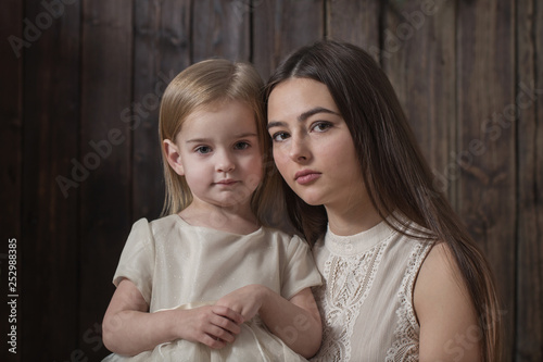mother and daughter on dark wooden background