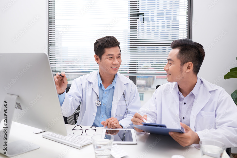Hardworking doctors reviewing patient's file Hardworking doctors reviewing patient's file