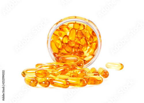 Omega 3 fish oil capsules spilling out of a bottle on white background photo