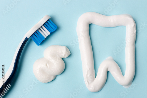 Toothpaste and toothbrush on blue background. Dental hygiene concept.