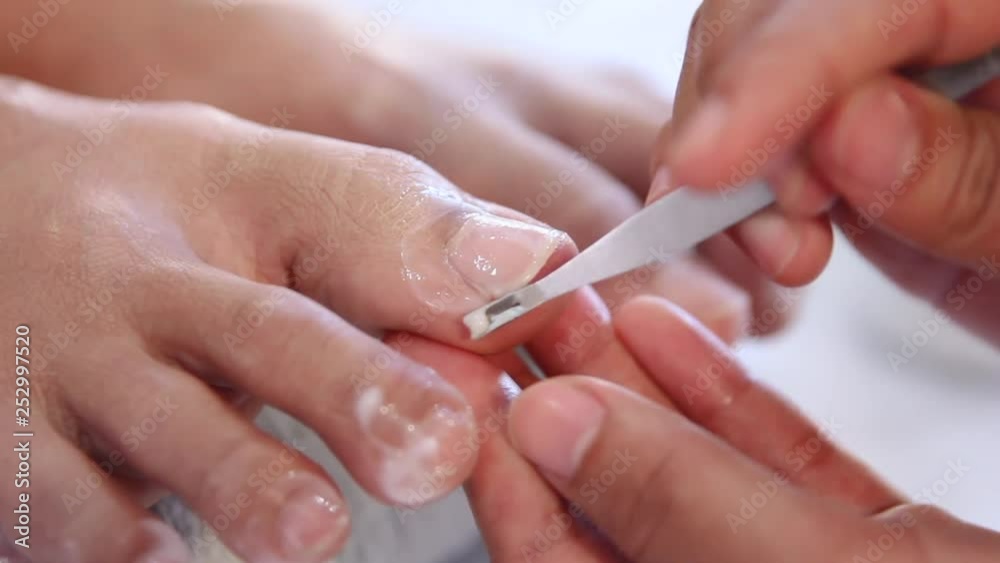 Beautician using a nail filer to give a nail pedicure Beautician using a nail filer to give a nail pedicure