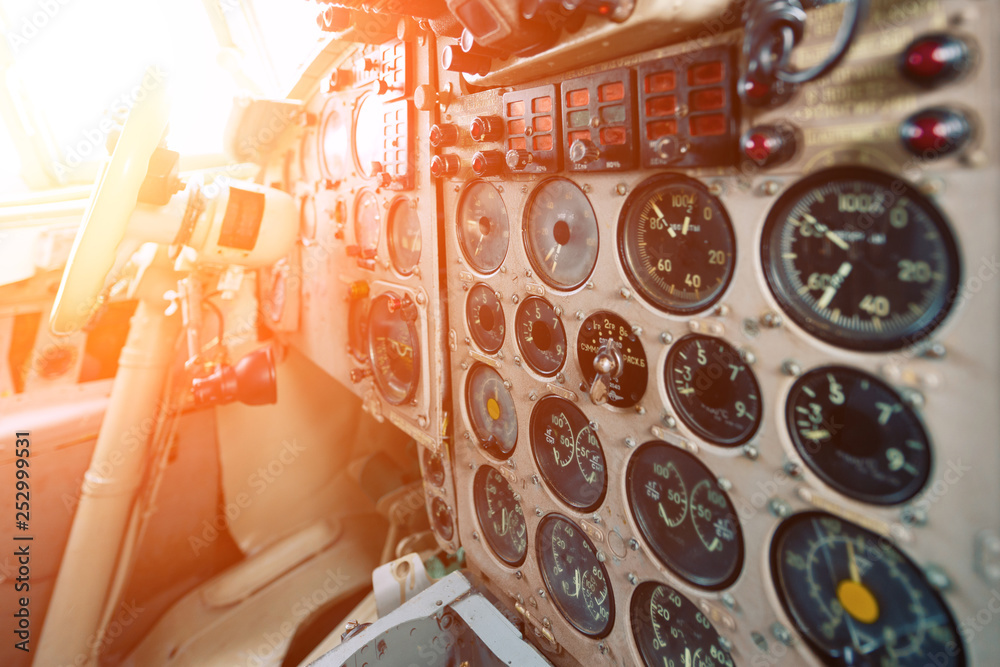 Dashboard of an old airplane. Many analog pointers, buttons and switches - obrazy, fototapety, plakaty 