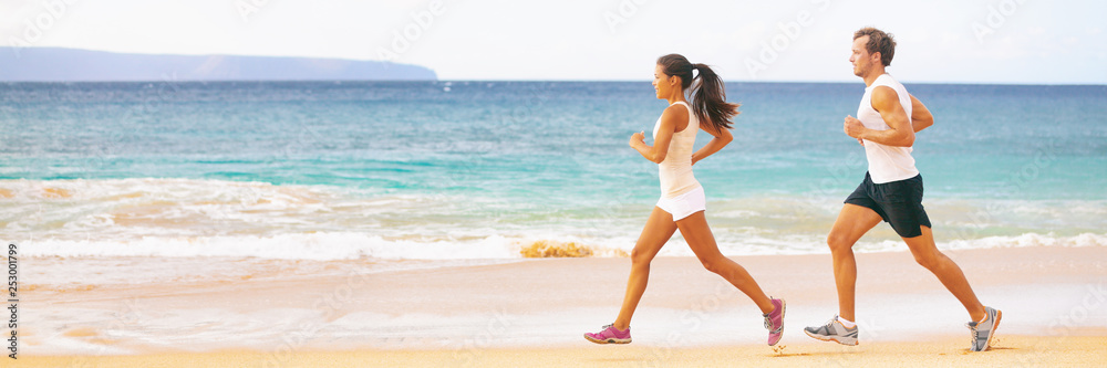 Run fit couple running together on beach banner panoramic background. Two fitness athlete jogging - summer active lifestyle. Run fit couple running together on beach banner panoramic background. Two fitness athlete jogging - summer active lifestyle.