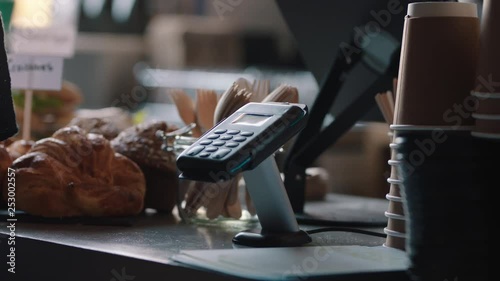 close up customer paying using credit card contactless payment in cafe spending money with wireless transaction in restaurant coffee shop