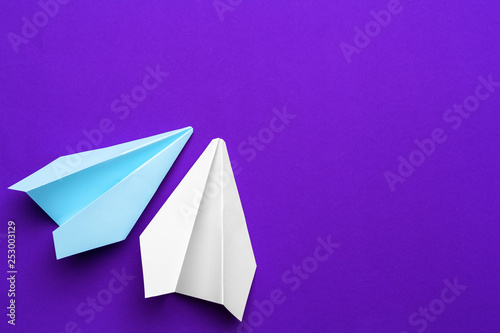 white paper airplane on a purple background