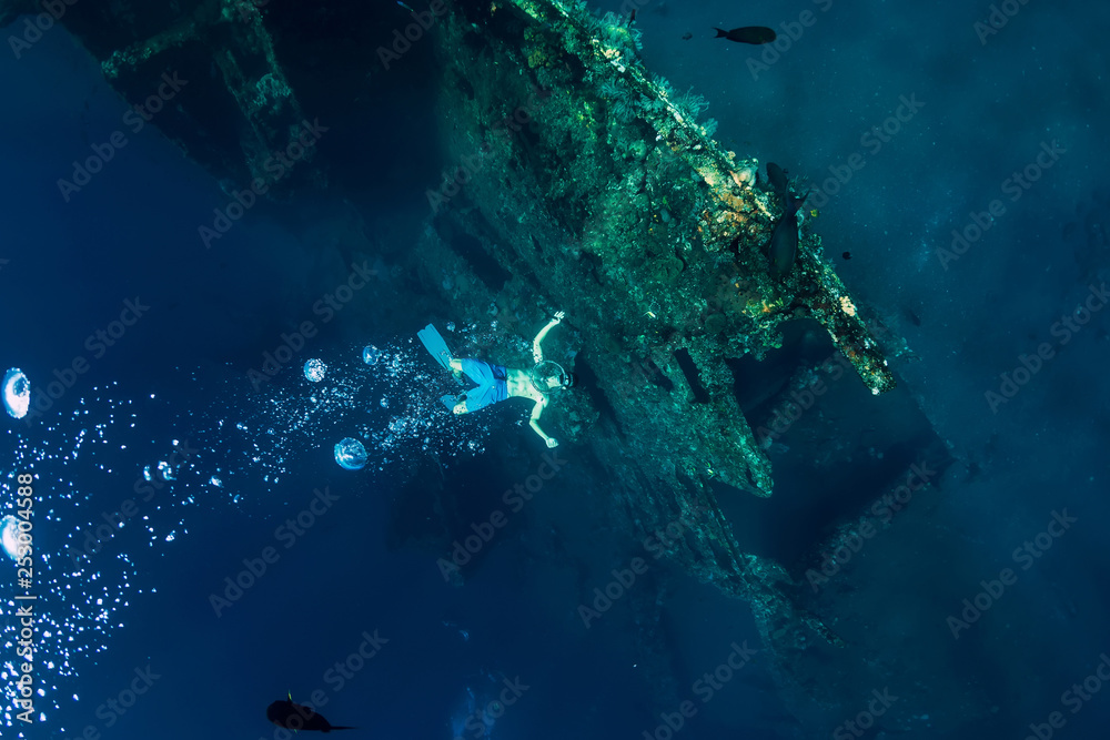 Obraz premium Człowiek-freediver robi bąbelki na podwodnym wraku statku na Bali