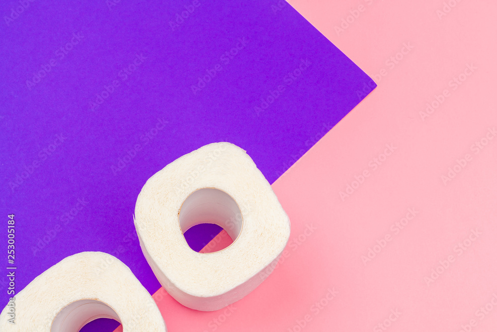 White toilet paper rolls on bright color block background White toilet paper rolls on bright color block background