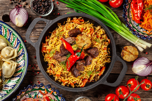 Traditional Uzbek oriental cuisine. Uzbek family table from different dishes in national dishes for the New Year holiday. The background image is a top view, copy space, flat lay