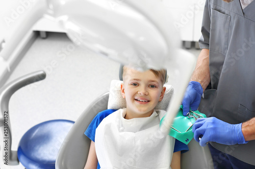 Dziecko u stomatologa. Dziecko na fotelu stomatologicznym podczas zabiegu leczenia zębów